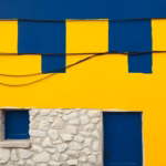Suprematist abstract painting inspired by Kazimir Malevich, featuring exposed electrical wires running along the wall of an old countryside stone house. Minimalist composition of bold navy blue and vibrant yellow geometric shapes on a stark white background. Flat textures, sharp edges, avant-garde electrical safety concept. No humans, no text.
