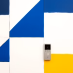 Suprematist abstract painting in the style of Kazimir Malevich featuring a wireless video intercom system: a sleek indoor touchscreen monitor beside a compact outdoor door panel with built-in camera and call button. Minimalist composition of bold navy blue and vibrant yellow geometric shapes on a stark white background. Flat textures, sharp edges, avant-garde smart home electrical concept. No humans, no text overlay.