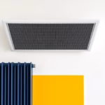 Suprematist abstract painting in the style of Kazimir Malevich featuring a ceiling heating panel and an electric inertia radiator. Minimalist composition of bold navy blue and vibrant yellow geometric shapes on a stark white background. Flat textures, sharp edges, avant-garde electrical concept. No humans, no text, no text overlay.