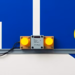 Abstract suprematist painting in the style of Kazimir Malevich showing an electrical impulse relay module mounted on a DIN rail, wired to push button switches and glowing lamp shapes. Minimalist composition of bold navy blue and vibrant yellow geometric shapes on a stark white background. Flat textures, sharp edges, avant-garde electrical concept art. No humans, no text, no lettering.