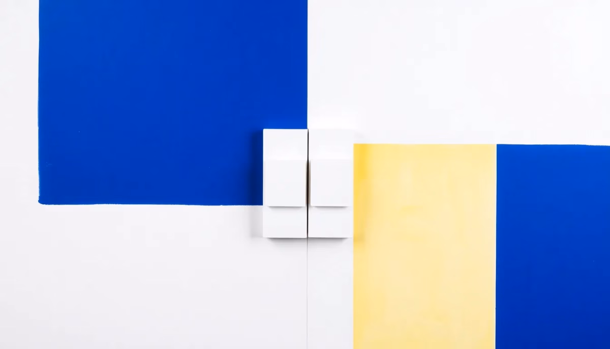 Suprematist abstract painting in the style of Kazimir Malevich representing a magnetic door and window contact sensor, split into two aligned rectangular blocks facing each other on a narrow vertical frame. Minimalist composition of bold navy blue and vibrant yellow geometric shapes on a stark white background. Flat textures, sharp edges, avant-garde electrical concept, clean studio lighting. No humans, no text, no lettering, no overlay.