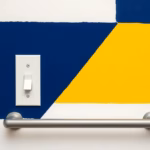 Suprematist abstract painting by Kazimir Malevich featuring a wall-mounted light switch plate and a horizontal grab bar positioned at an accessible height of about 1.10 m from the floor. Minimalist composition of bold navy blue and vibrant yellow geometric shapes on a stark white background. Flat textures, sharp edges, avant-garde electrical concept, no humans, no text.