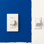 Suprematist abstract painting in the style of Kazimir Malevich featuring a vintage ceramic push-button light switch being replaced by a modern flat rocker switch. Minimalist composition of bold navy blue and vibrant yellow geometric shapes on a stark white background. Flat textures, sharp edges, avant-garde electrical concept. No humans, no text, no lettering, no overlays, no watermarks.